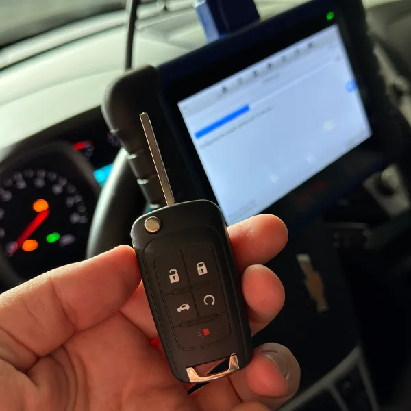 Chevrolet flip key being programmed with a diagnostic tablet inside the car