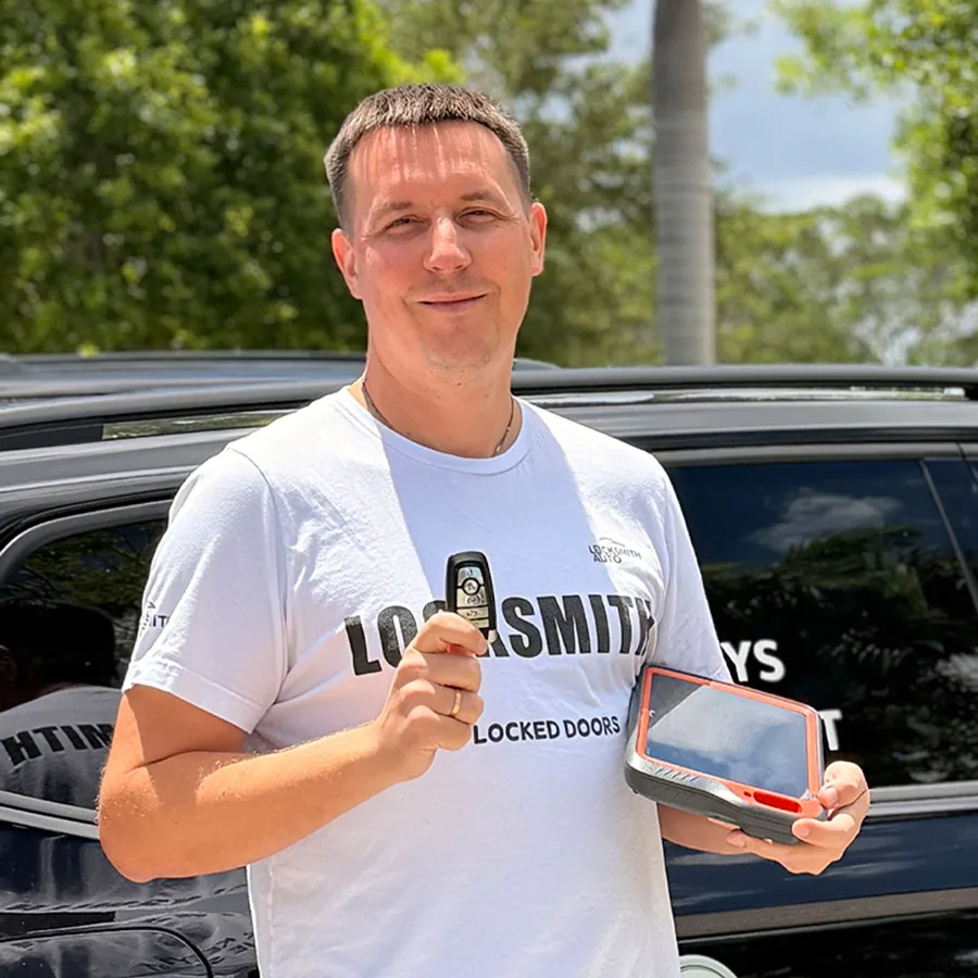 Tikhon, owner of Locksmith Auto, with a new Ford key and a key programmer